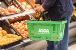A customer holds a basket of groceries inside an Asda store, trialing new sustainability initiatives, in Middleton, U.K.