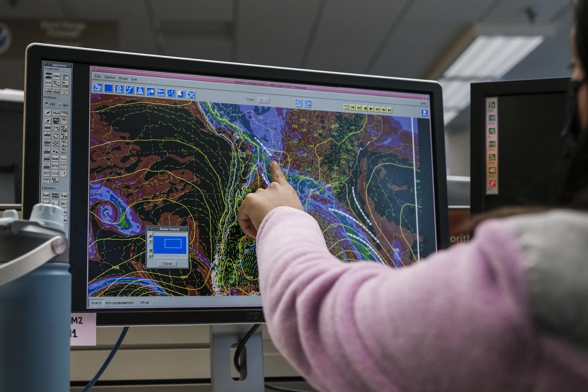 A meteorologist monitors weather activity on a computer screen.
