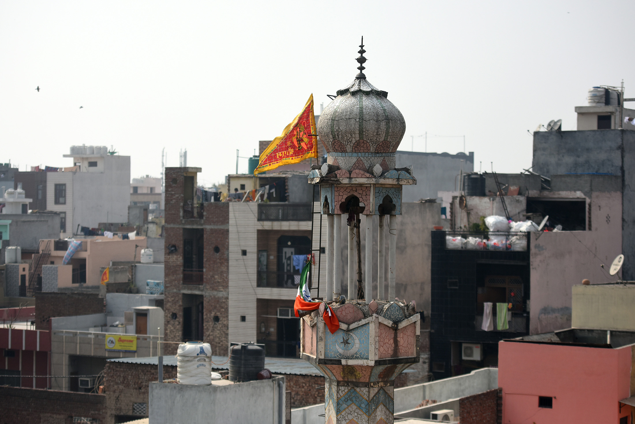 A Hindu flag flies on a minaret of a mosque that was burnt&nbsp;during clashes over the new citizenship law in Delhi on&nbsp;Feb. 26.