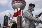 Pedestrians walk past a Chinese flag in the Lujiazui financial district in Shanghai on Dec. 1.