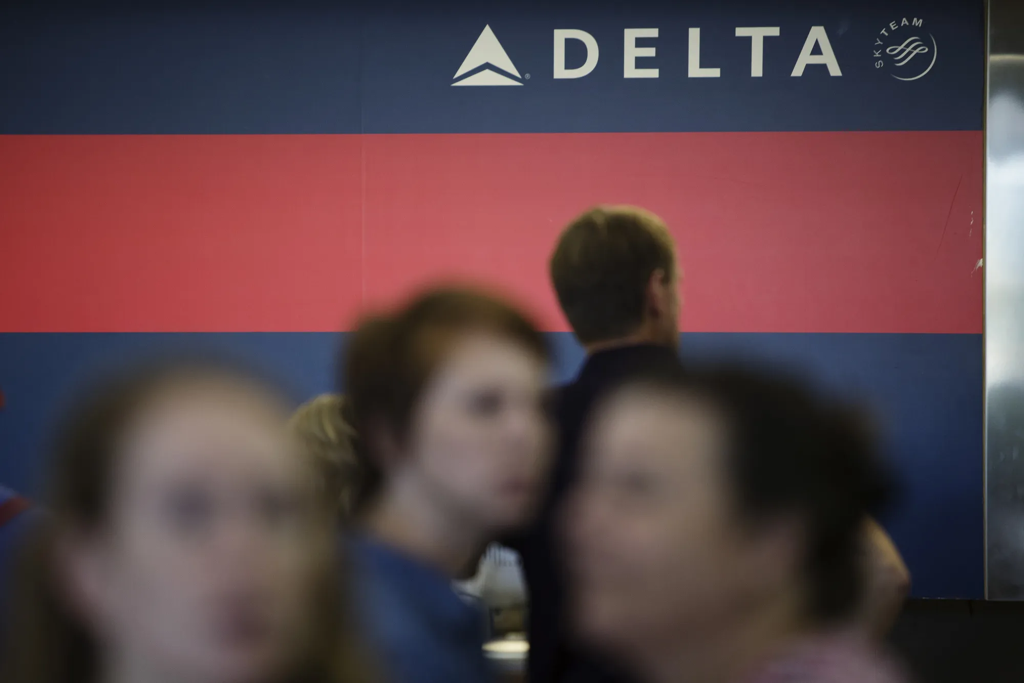 Passengers wait for updated Delta Airlines Inc. flight status information at LaGuardia Airport in Queens,&nbsp;New York.