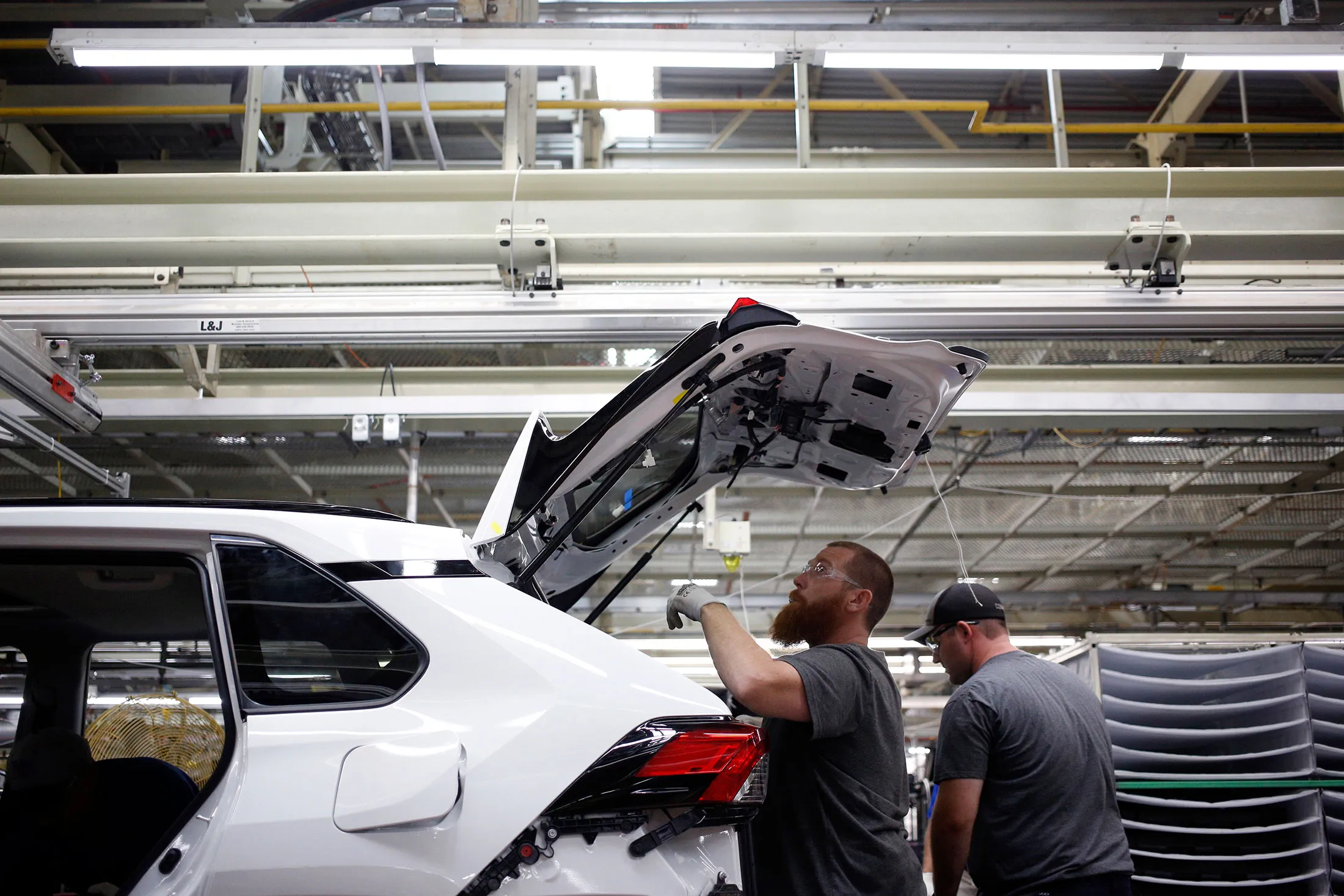 A factory worker practices installing parts on a preproduction hybrid RAV4.