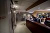 Two hospital employees work at a nurses’ stand in the ICU adjacent to patient rooms covered in plastic sheeting.