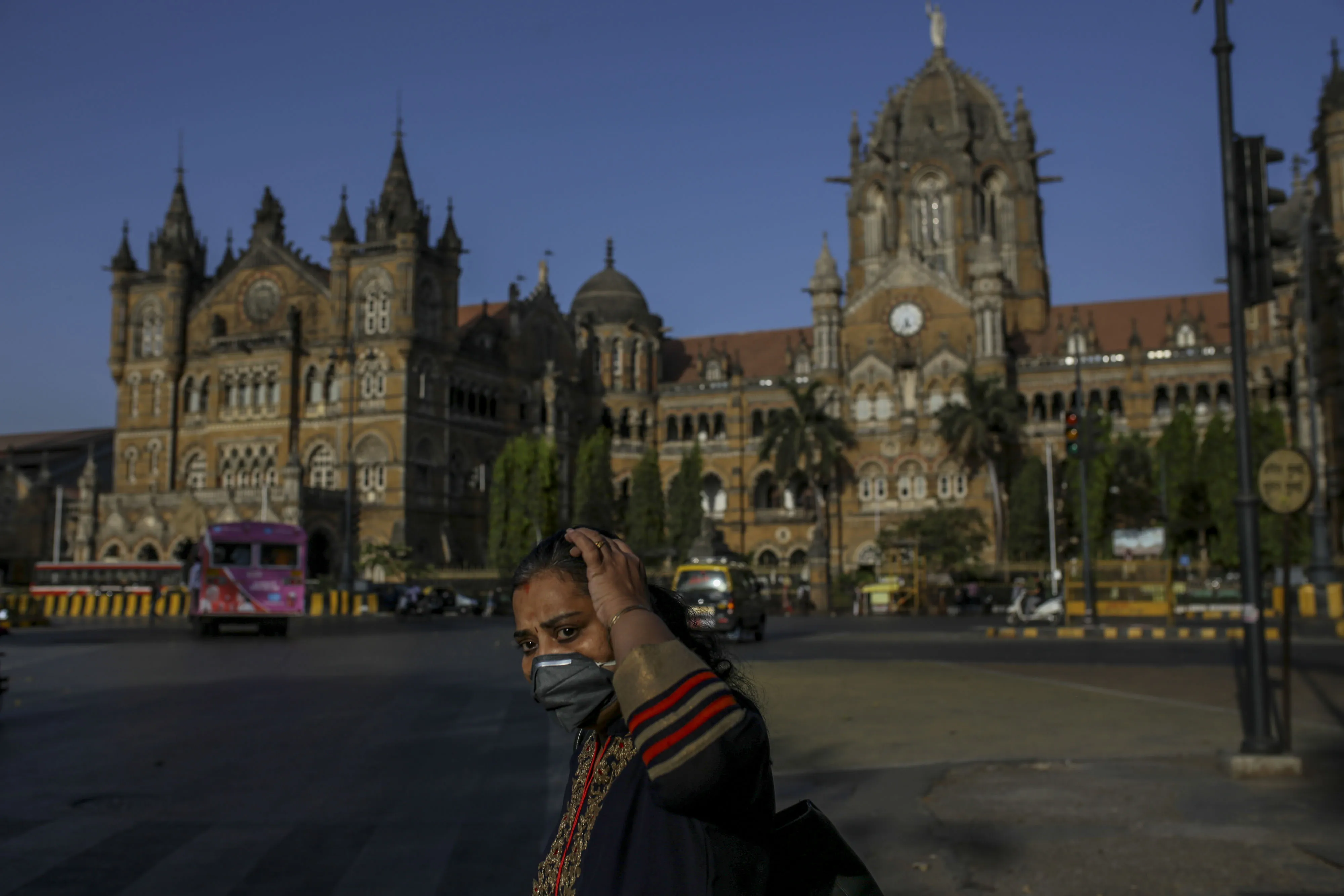 A pedestrians wearing a protective mask walks past the Chhatrapati Shivaji Terminus (CST) train station in Mumbai on&nbsp;March 21.