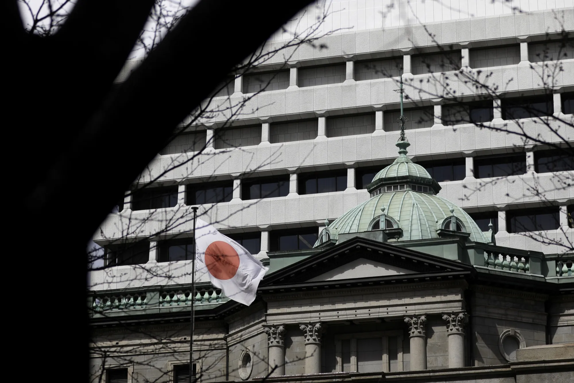 A Japanese national flag flies outside the Bank of Japan&nbsp;headquarters in Tokyo.
