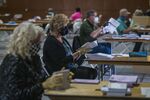 Volunteers wearing protective masks and gloves sort through early voting ballots in Martinez, California, U.S., on Wednesday, Oct. 28, 2020. 