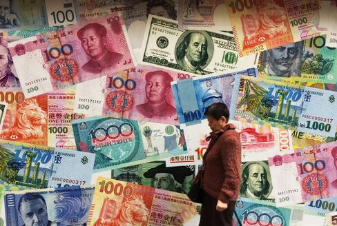 A combo of Chinese currency RMB or Yuan, US Dollar, Hong Kong Dollar and other currencies notes is seen outside a foreign exchange shop in Hong Kong on March 12, 2015.