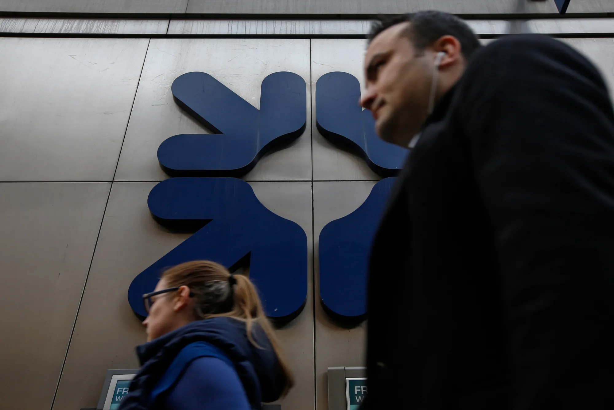 Commuters pass a&nbsp;Royal Bank of Scotland Group Plc bank branch in London.