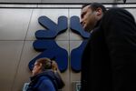 Commuters pass a&nbsp;Royal Bank of Scotland Group Plc bank branch in London.