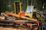 A worker removes freshly cut boards from a Sooke, British Columbia sawmill in October 2021.