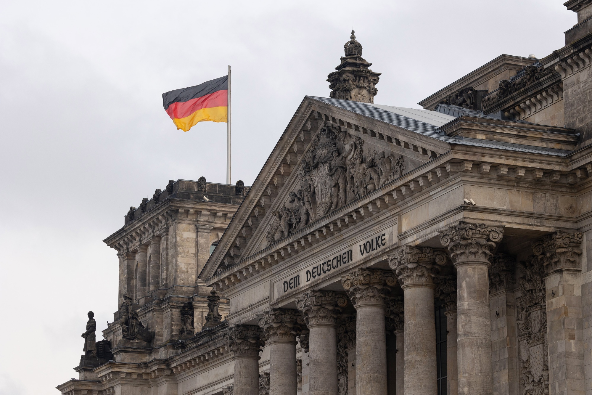 A German national flag flies above the Reichstag building in Berlin.
