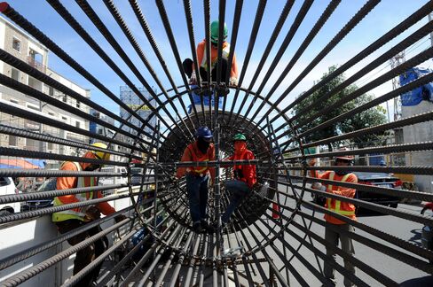 Construction workers prepare to put up a column for an elevated highway project in Manila.