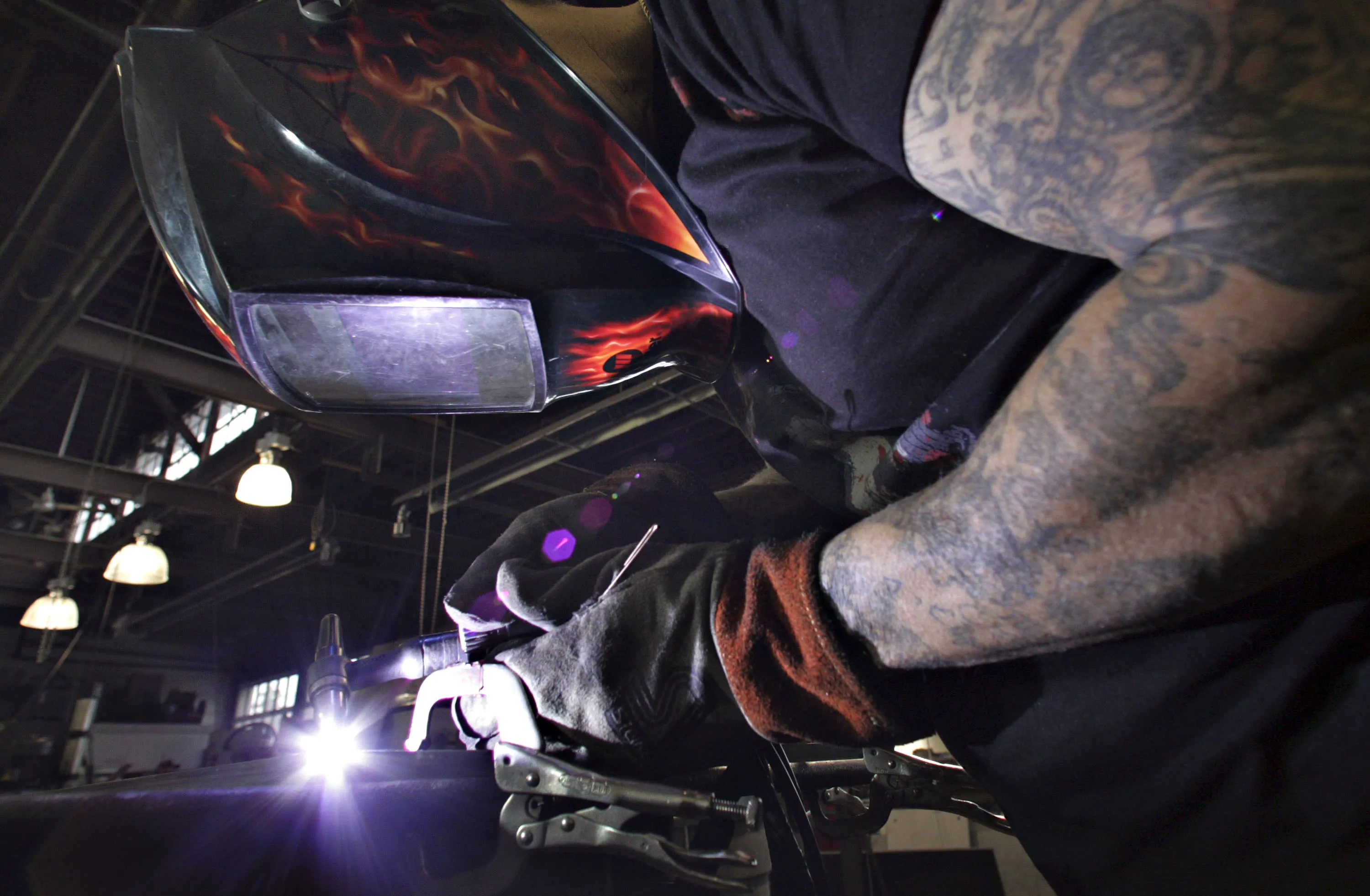 A worker welds steel pieces for lighting fixtures at Kevin Reilly Enterprises in Montgomery, Alabama, U.S.