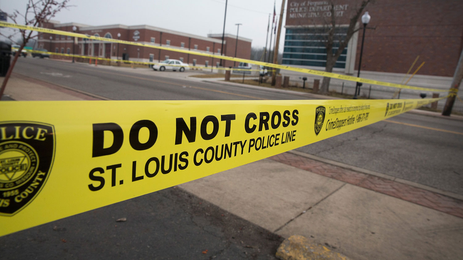 Law enforcement officials secure the crime scene and continue to search for evidence outside the police station after two officers were shot and wounded during last night's protest on March 12, 2015 in Ferguson, Missouri.
