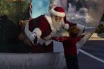 A performer dressed as Santa Claus greets a child from inside a big snow globe in Oklahoma City, Oklahoma, on Dec. 5, 2020.