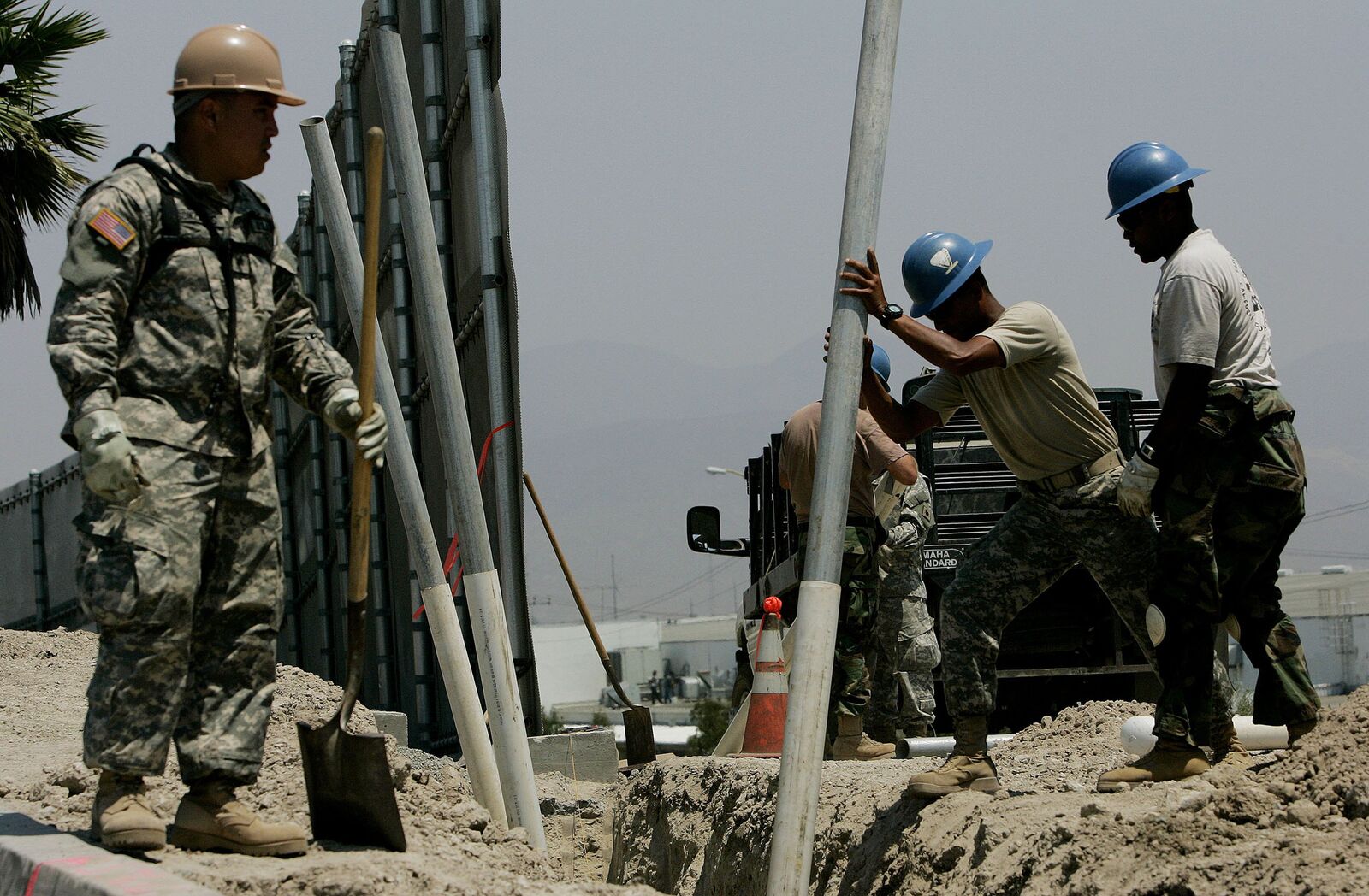 OTAY MESA, CA - JULY 25: Members of the California National Guard prepare to bury plastic pipes for housing electrical wiring along the U.S.-Mexico Border July 25, 2006 in Otay Mesa, California. Approximately 1,000 volunteer Guardsmen are stationed along the California-Mexico border as part of Operation Jump Start, which is providing support for the border patrol agents by repairing fences, improving roads and manning surveillance cameras. The Guard are prohibited from engaging in overt law enforcement. (Photo by Sandy Huffaker/Getty Images)