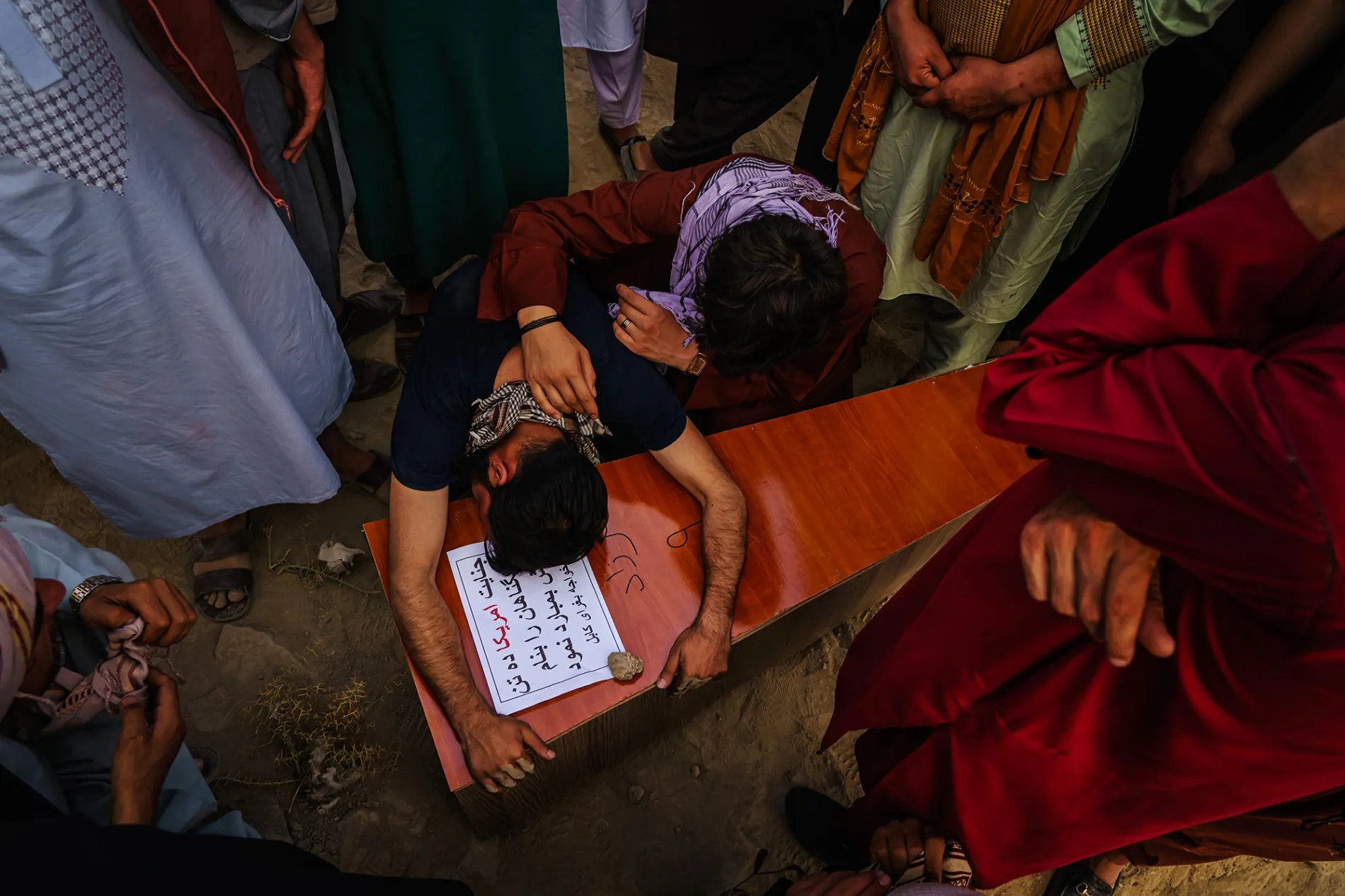 A relative mourns over the casket of a child killed by the U.S. drone strike in Kabul.