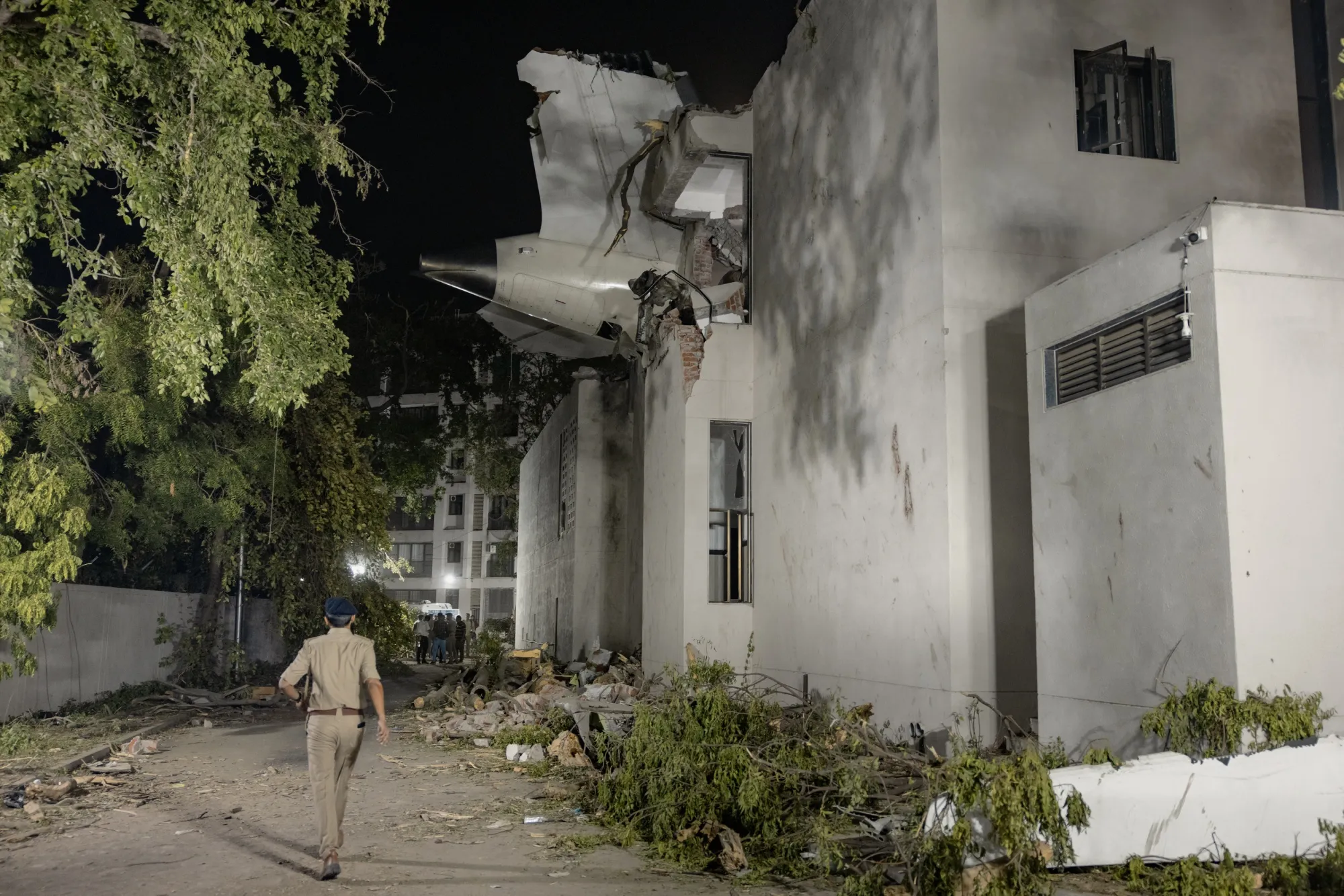 The tail of the Air India aircraft protrudes from a hostel where it crashed, in Ahmedabad.