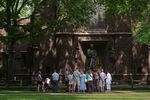 A tour group makes a stop at a statue of Theodore Woolsey on the Yale University campus.