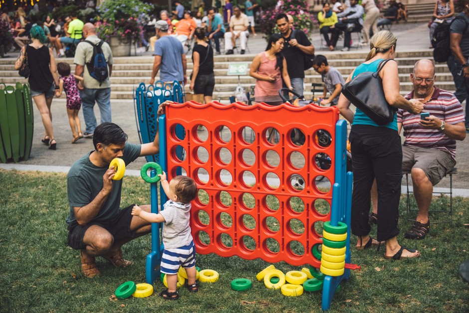 A toddler plays giant Connect Four at Bryant Park in New York City.