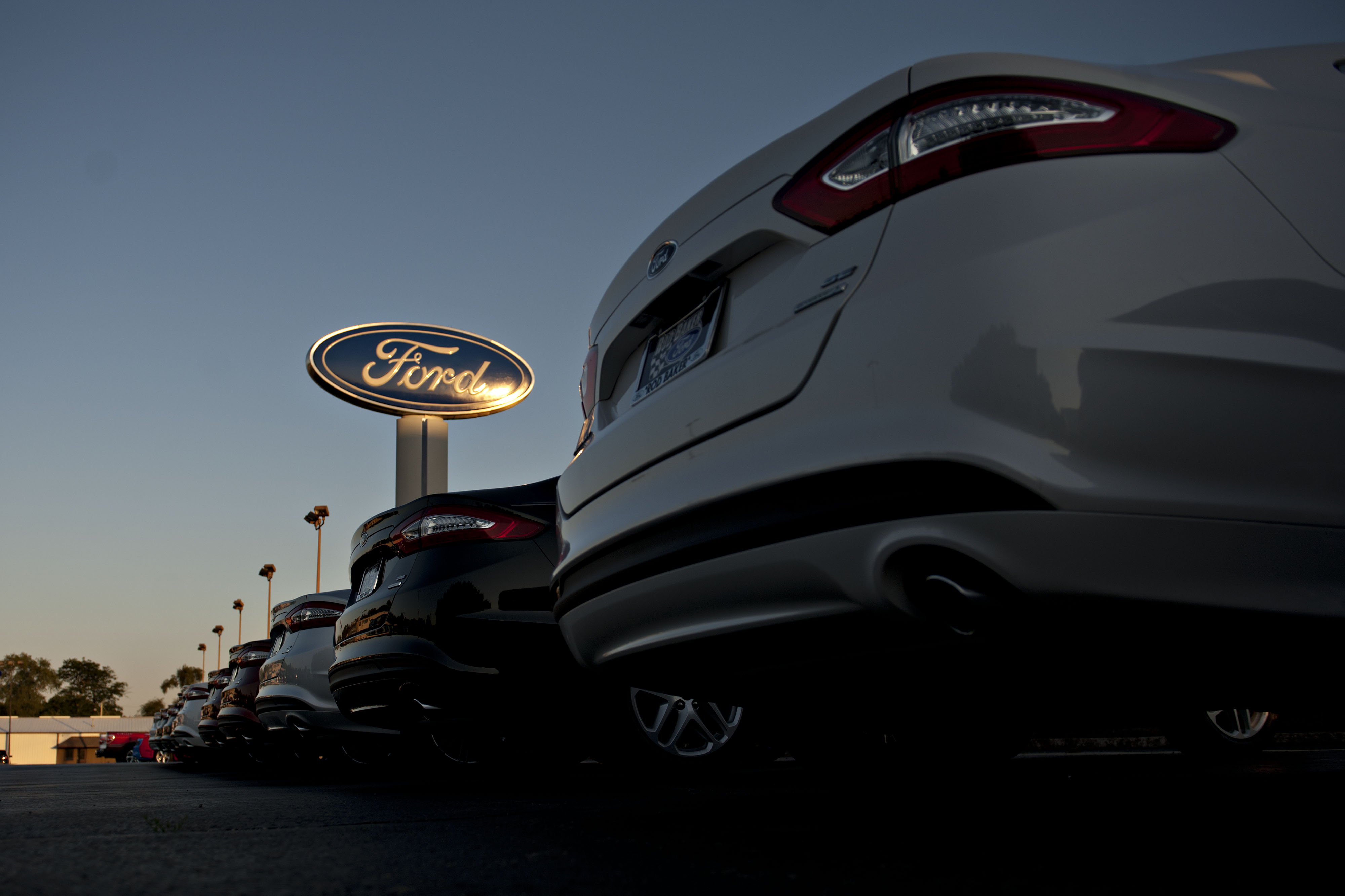 A Ford Motor sign stands near a row of vehiclses in Plainfield, Illinois.
