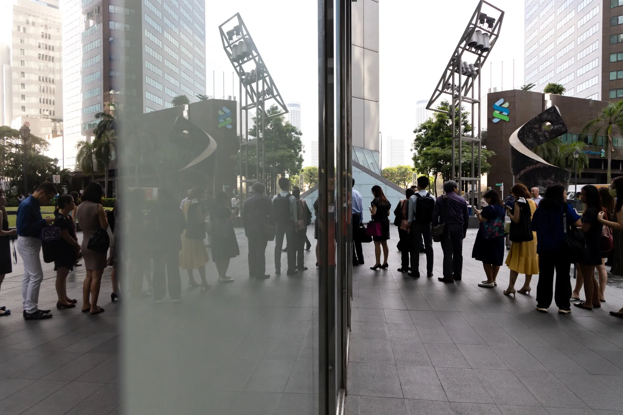 People stand in line for a temperature check outside an office building in the central business district of Singapore, on&nbsp;Feb. 10.