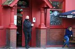 A security guard uses hand sanitser&nbsp;outside a pub in Liverpool,&nbsp;on Oct.&nbsp;11.&nbsp;