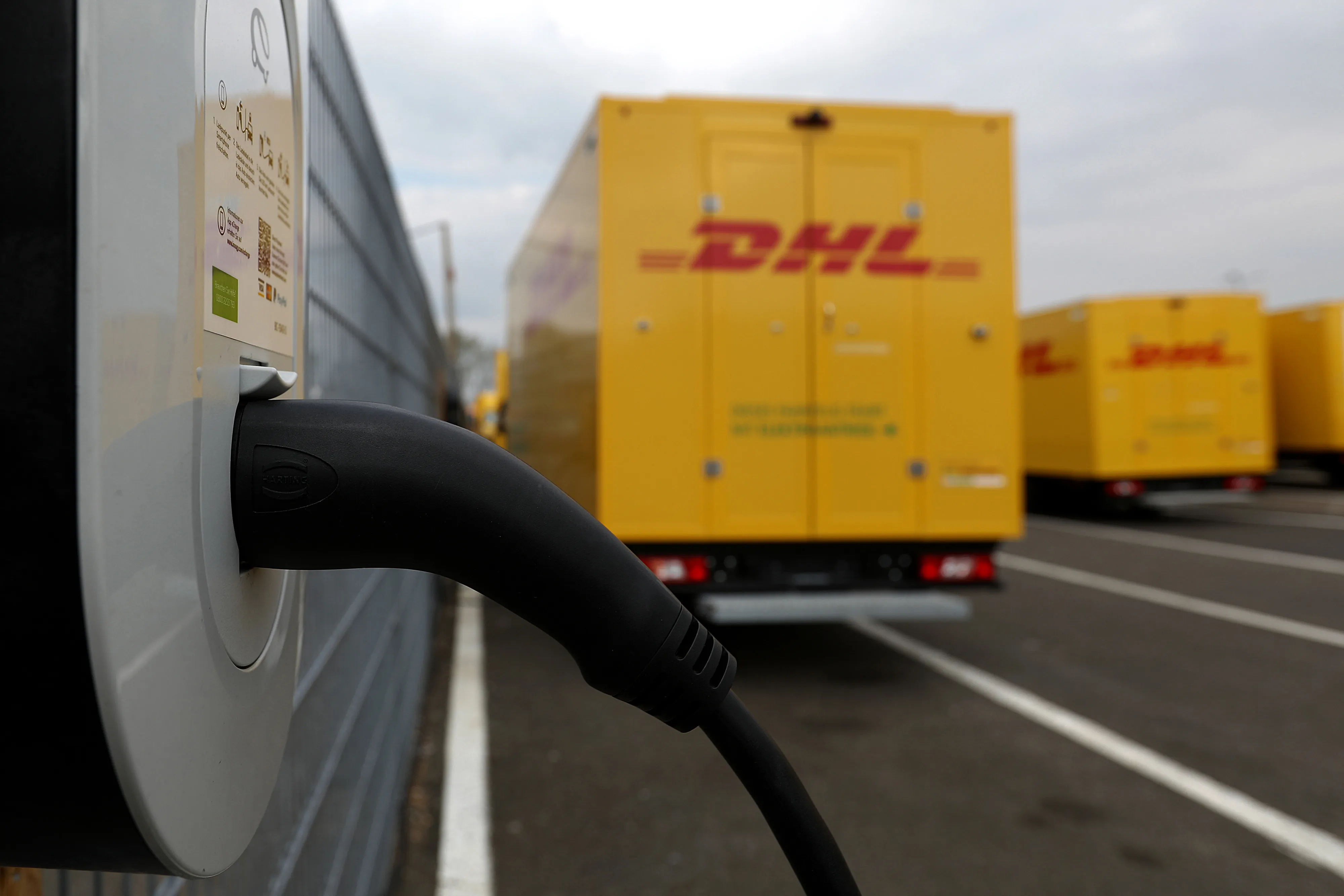 An electric cable charges a StreetScooter delivery truck outside the Ford factory in Cologne, Germany.