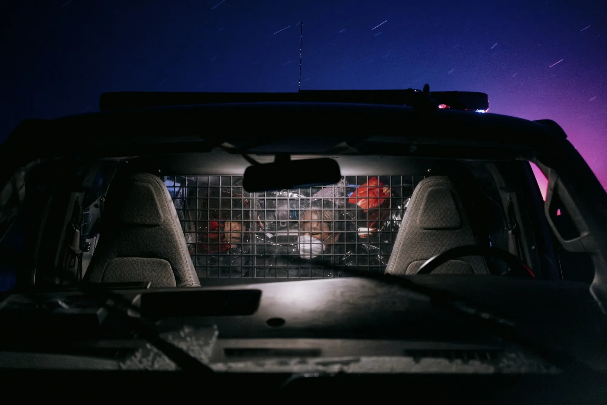 Migrants in a US Border Patrol vehicle wait to be transported for asylum claim processing at the US-Mexico border in Campo, California, in April.&nbsp;