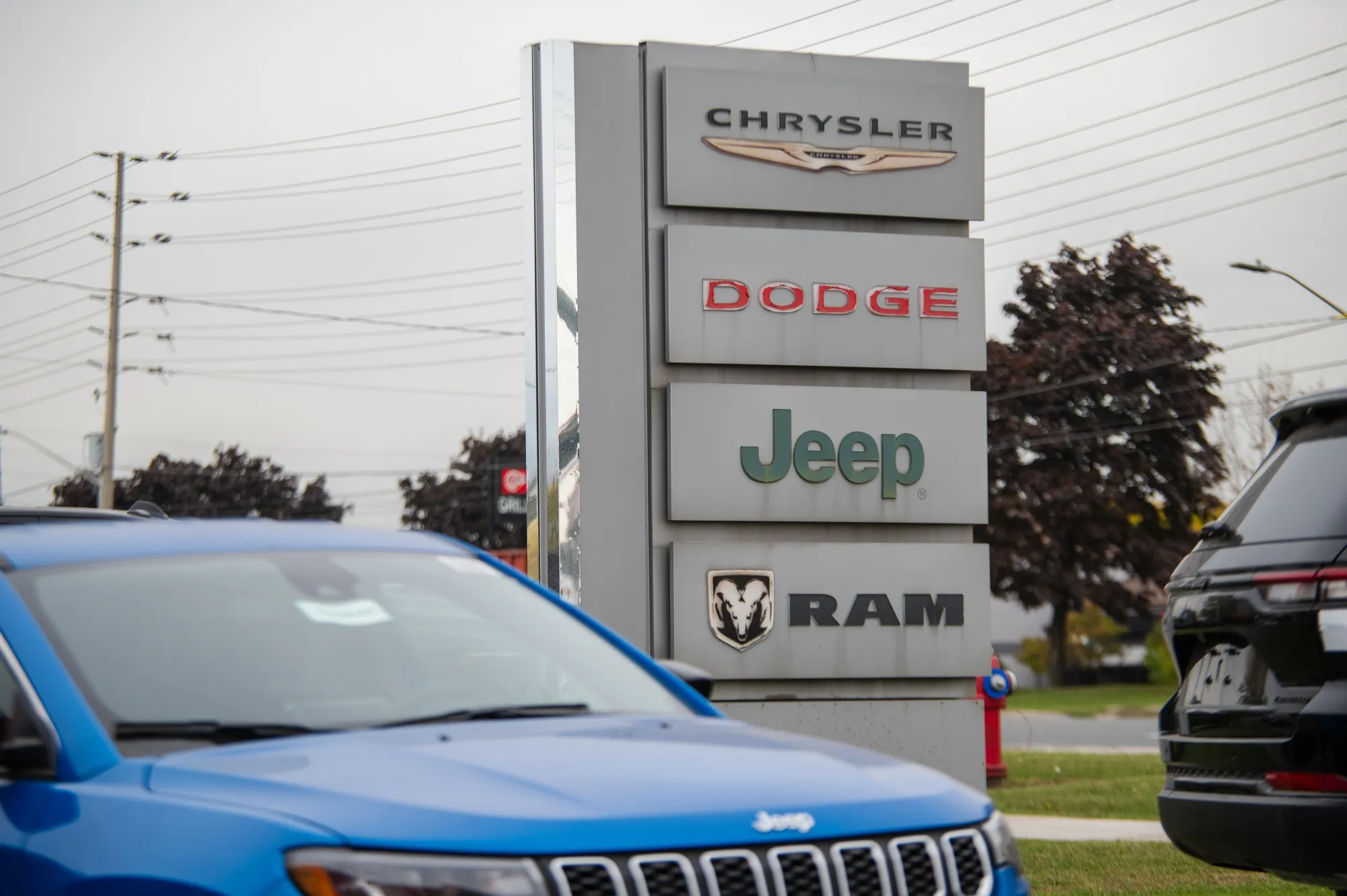 Chrysler, Dodge, Jeep, and Ram signs at a dealership in Mississauga, Ontario.