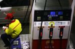 A petrol attendant works at a gas station in Fuzhou, China.