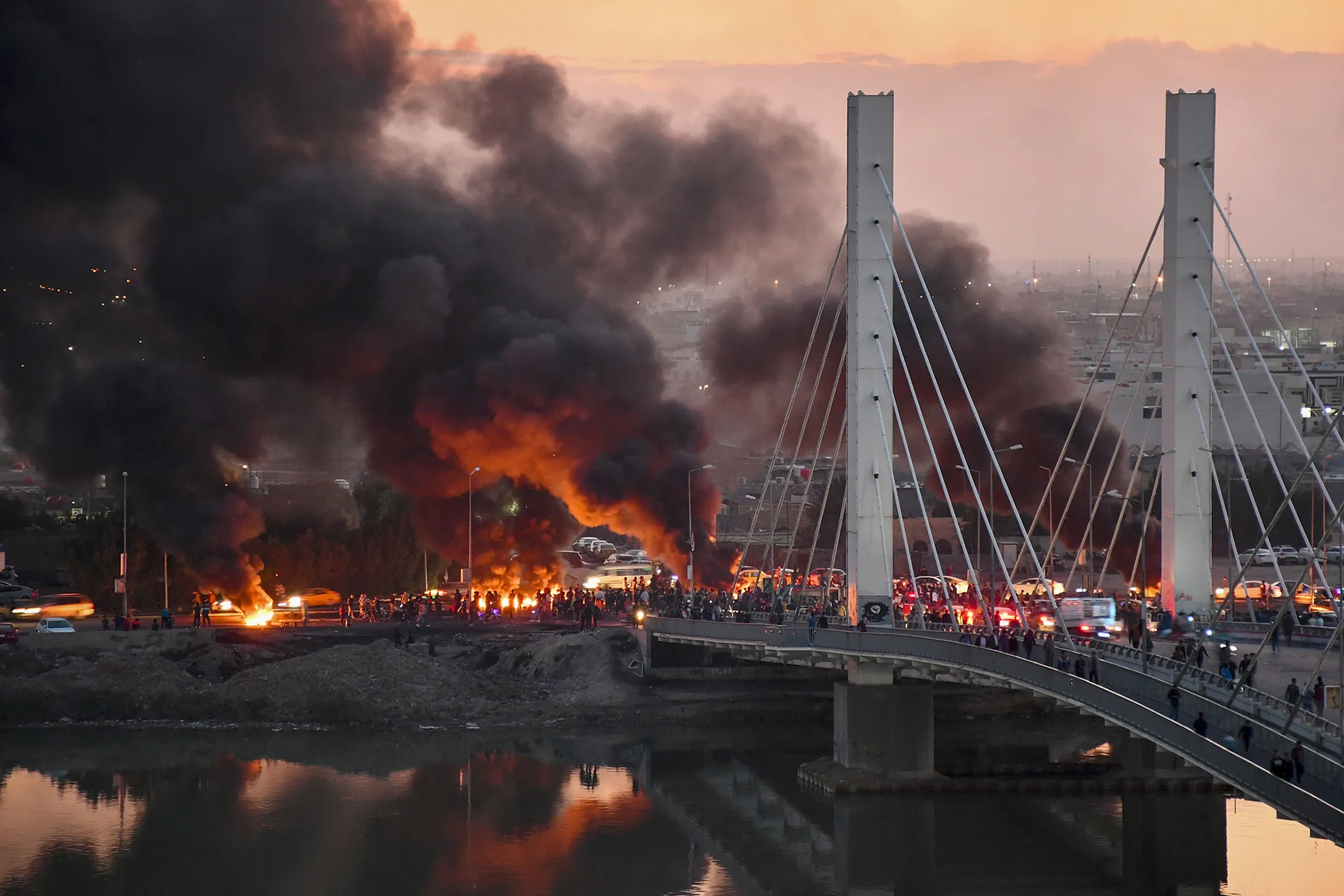&nbsp;Iraqi Anti-government demonstrators block a bridge with debris and burning tires in the southern Iraqi city of Nasiriyah on Jan.&nbsp;19.