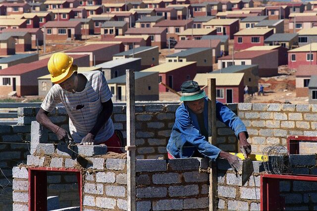 Construction workers build homes for a new low-cost housing project in Johannesburg's Alexandra township, in April 1999.