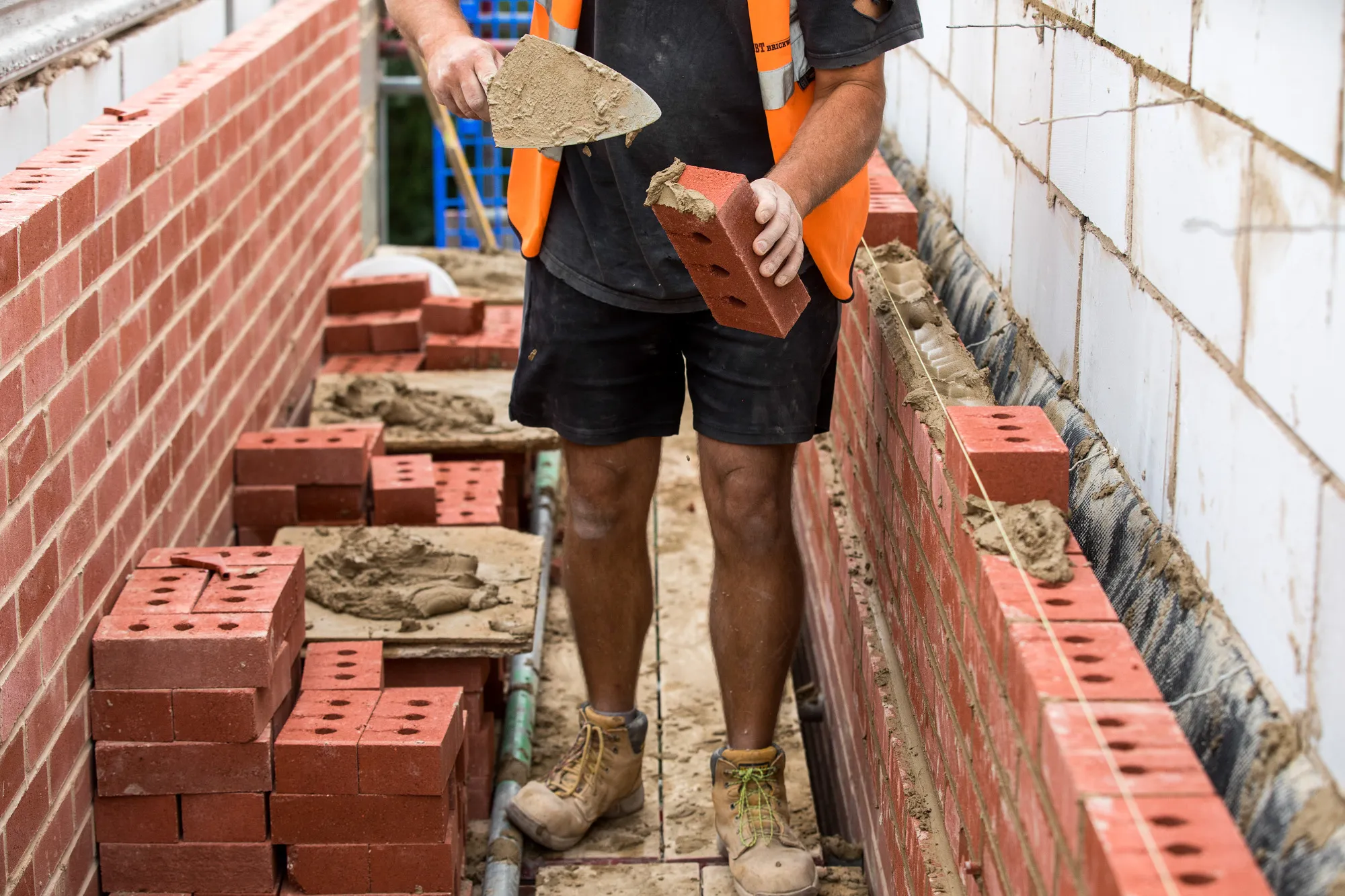 A bricklayer puts cement on bricks at a&nbsp;residential construction site in Grays.
