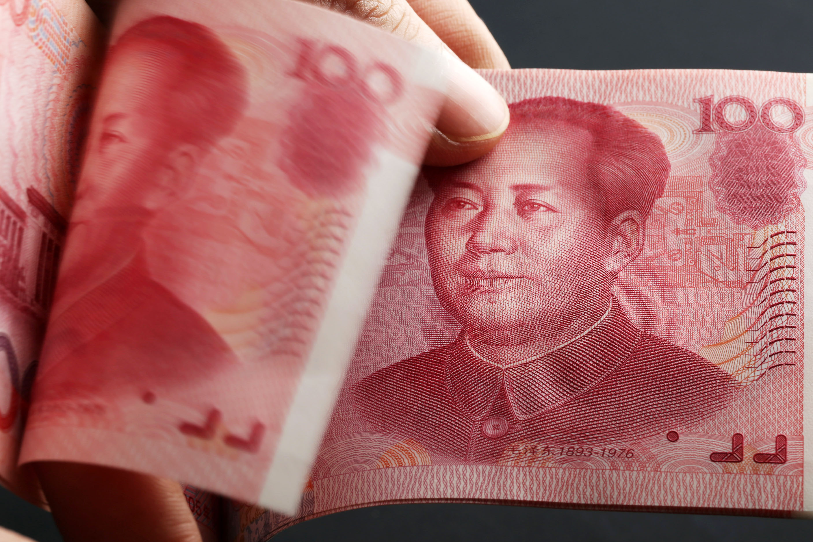 Chinese one-hundred yuan banknotes are arranged for a photograph.
