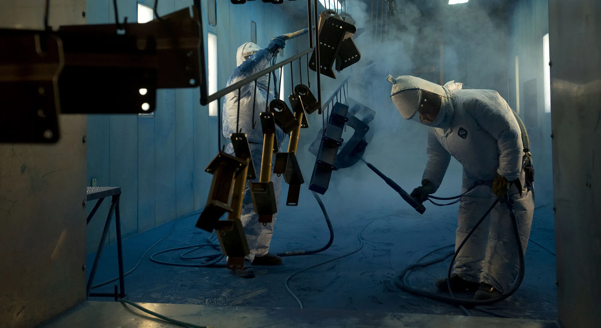 Workers powder-coat components at a facility in Williamsburg, Iowa.