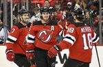 New Jersey Devils center Jack Hughes (86) celebrates his goal against the Vancouver Canucks with center Dawson Mercer (18) and defenseman Dougie Hamilton (7) during the first period of an NHL hockey game Monday, Feb. 28, 2022, in Newark, N.J. (AP Photo/Bill Kostroun)