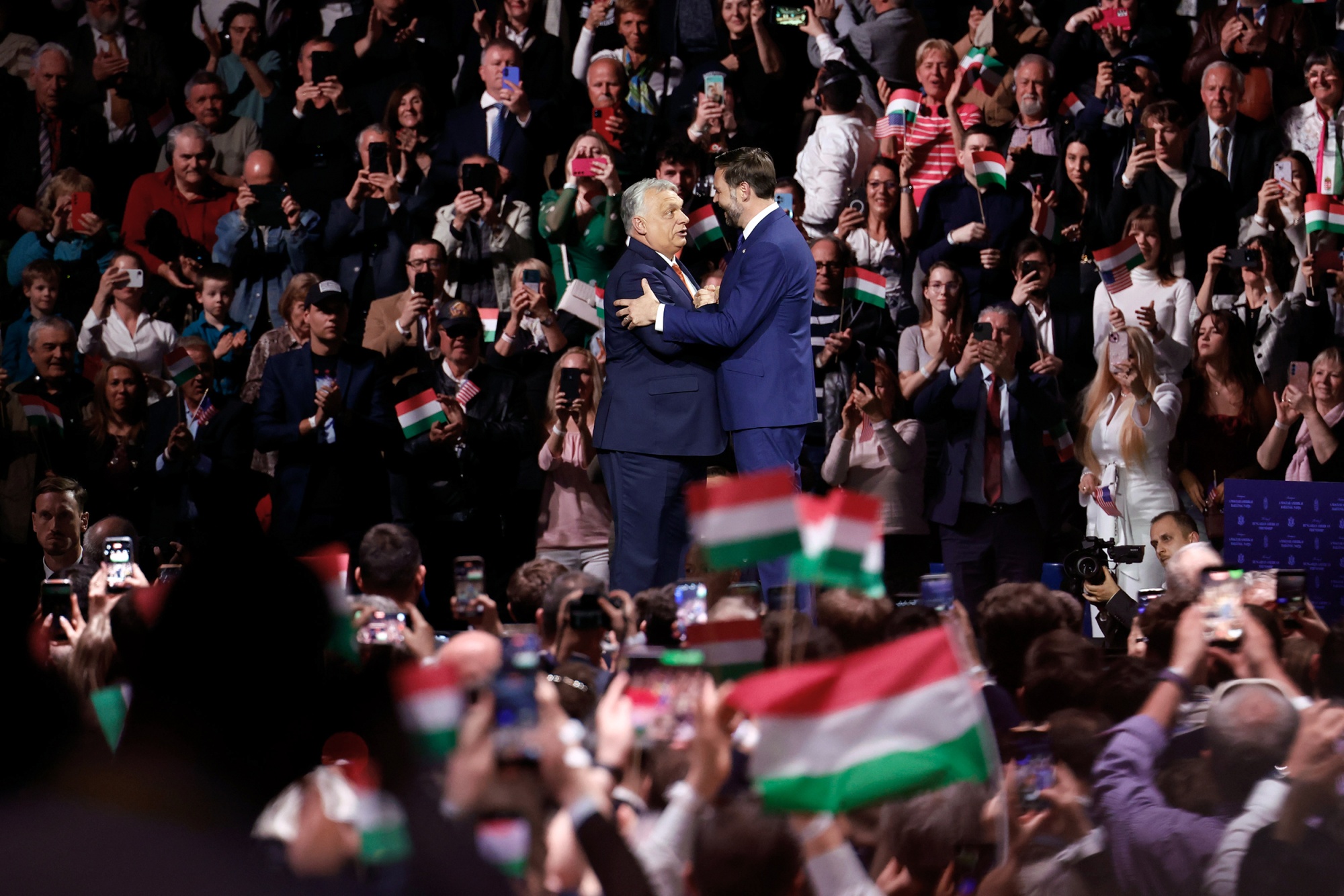 Viktor Orban, Hungary's prime minister, left, and US Vice President JD Vance, embrace at a pre-election rally in Budapest, Hungary, on Tuesday, April 7, 2026. With five days until elections in Hungary, Orban is hoping that the visit of US Vice President JD Vance to Budapest can turn things around. Photographer: Akos Stiller/Bloomberg