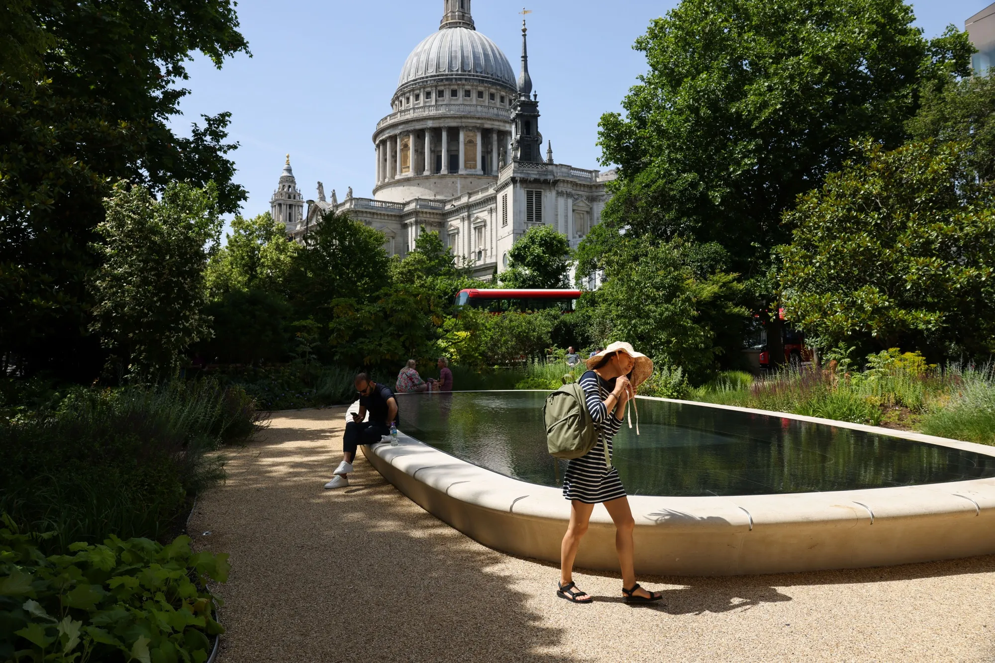 A pedestrian shelters from the sun under a hat in London on Friday, June 17.