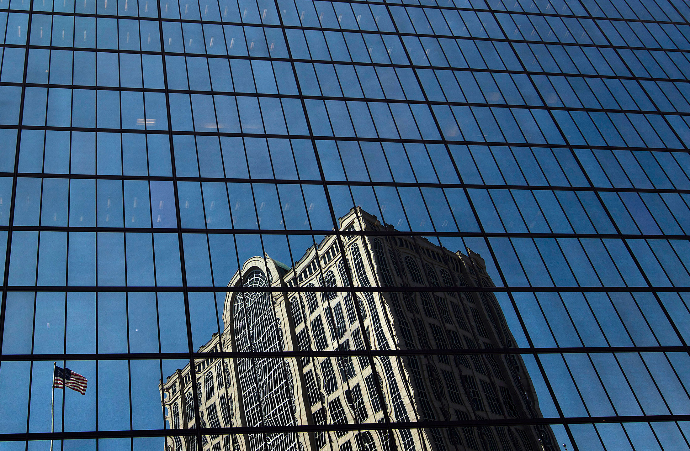 A building is reflected in the John Hancock Tower, Bain Capital LLC's headquarters in Boston, Massachusetts.
