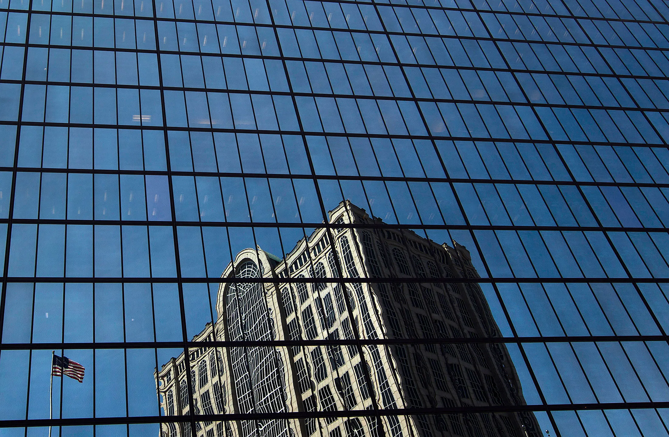 A building is reflected in the John Hancock Tower, Bain Capital LLC's headquarters in Boston, Massachusetts.
