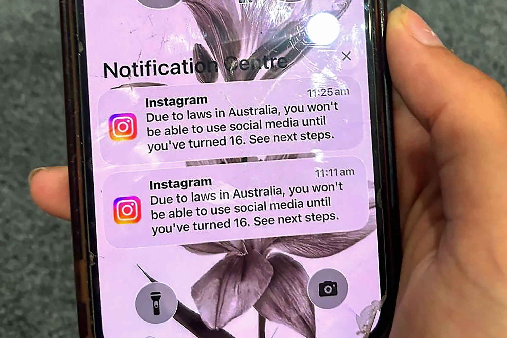 A teenager holds a mobile phone displaying a message from Instagram after the account was locked for age verification in Sydney on Dec. 9, 2025.
