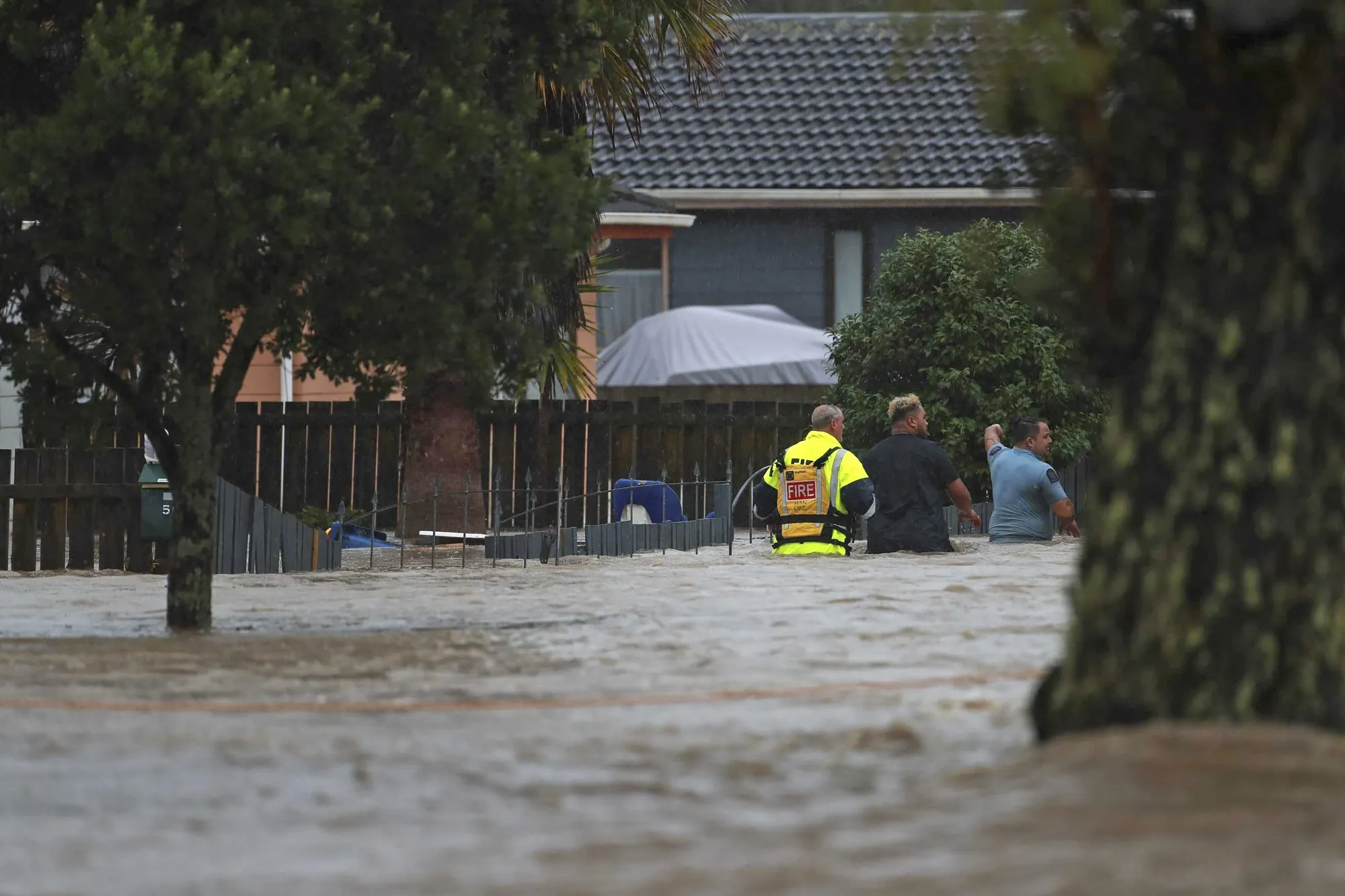 Emergency workers assist residents through flood waters in Auckland, on Jan. 27.