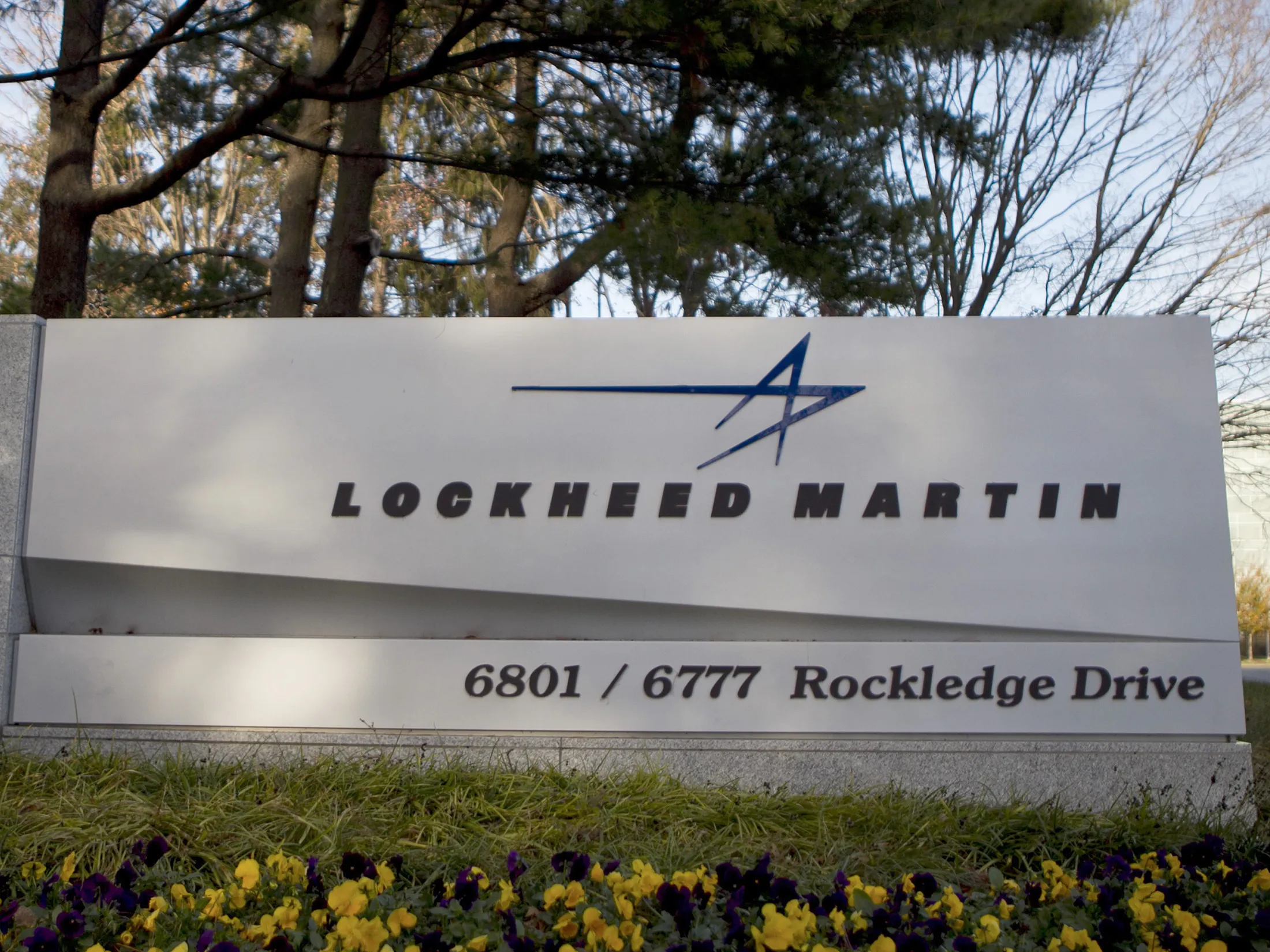 Trees surround a sign for Lockheed Martin Corp. standing outside the company's headquarters in Bethesda, Maryland, U.S.