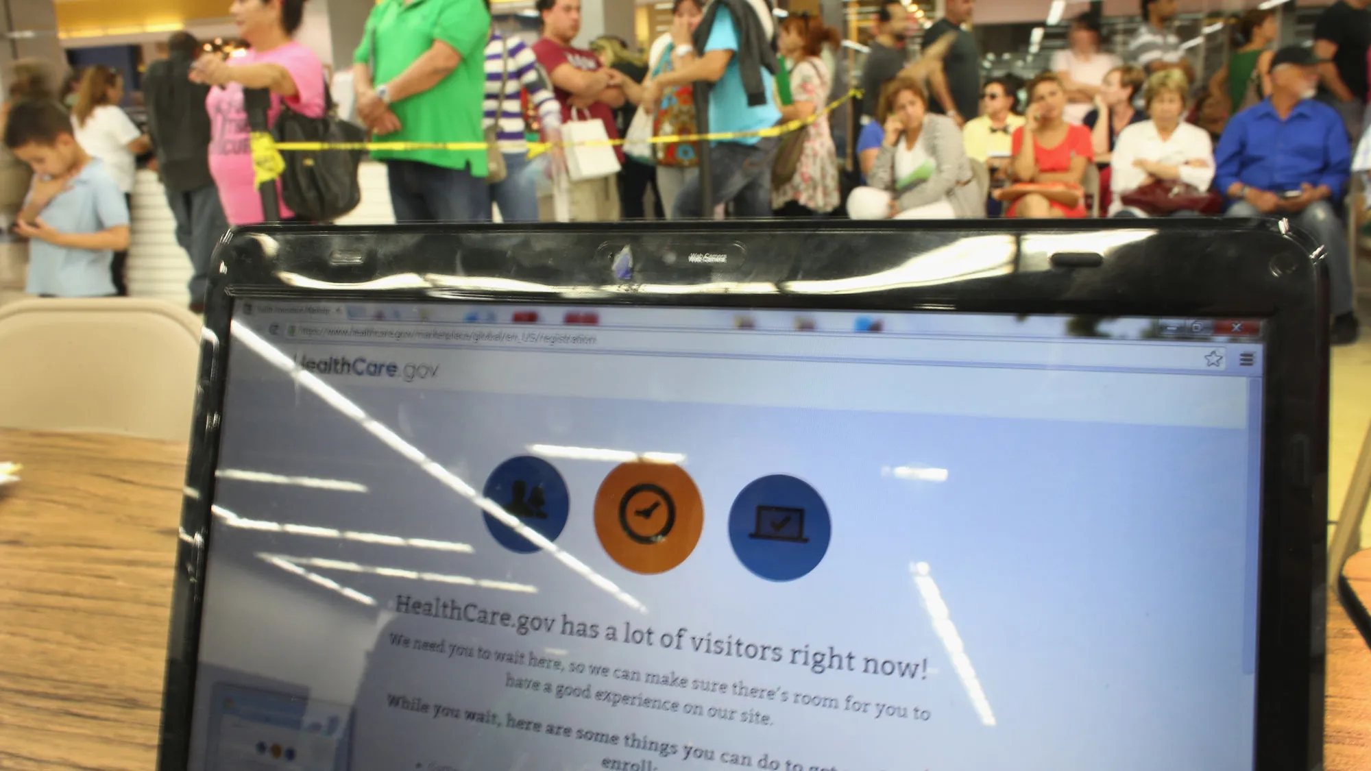 : People wait in line to see an agent from Sunshine Life and Health Advisors as the Affordable Care Act website is reading, 'HealthCare.gov has a lot of visitors right now!...
