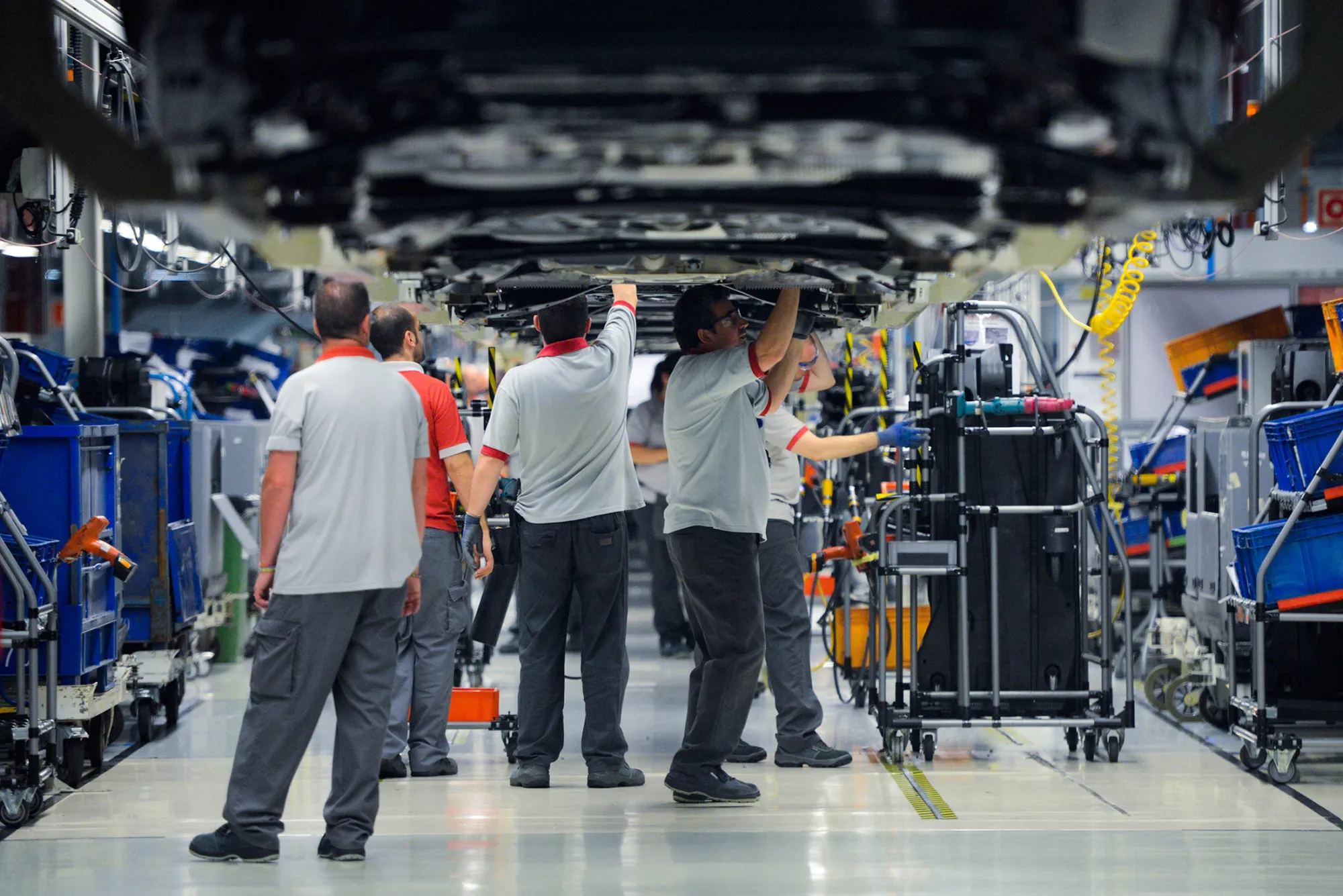 Employees work on Seat Leon vehicles on the production line during assembly at Volkswagen AG's Seat automobile plant in Martorell, Spain, on Tuesday, July 15, 2014. Seat plans to add a compact sports-utility vehicle to its lineup in 2016 to tap growth in a market segment the division estimates has grown more than 40 percent in the last five years in Europe.
