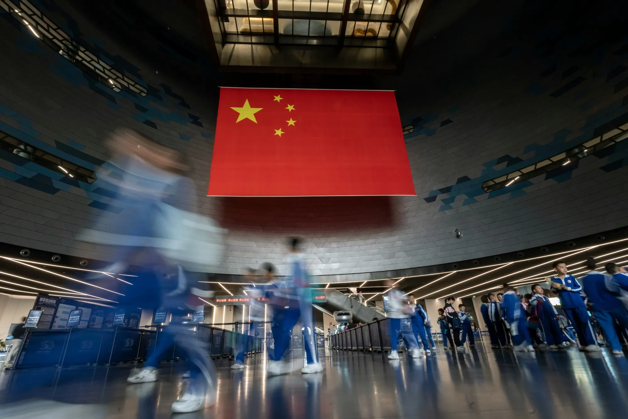 A group of students in front of a Chinese flag.