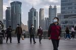 Pedestrians wearing protective masks walk through the Lujiazui financial district in Shanghai, China, on Tuesday, Dec. 1, 2020. China unexpectedly added medium-term funding to the financial system on Monday, as the central bank sought to ease liquidity tightness in the final weeks of the year.