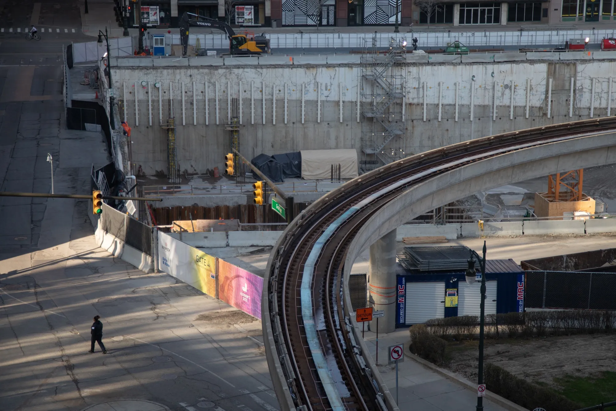 A pedestrian walks near a halted construction site in Detroit.