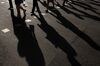 The shadows of morning commuters are cast as they cross the road in the central business district of Singapore, on Wednesday, Sept. 14, 2016. The currency market has shifted to signal expectations the Monetary Authority of Singapore will refrain from easing next month, with a measure of the local dollar's potential direction sliding to a four-year low.